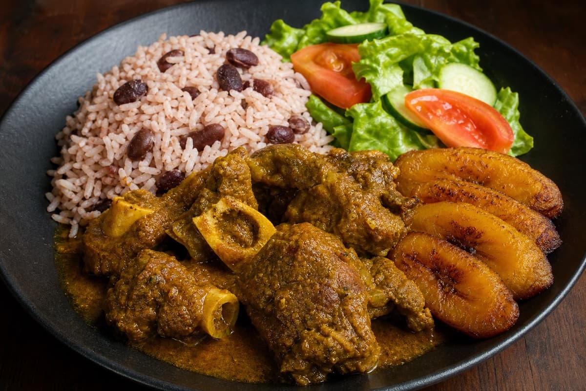 Goat curry with rice and peas, plantain and garden salad